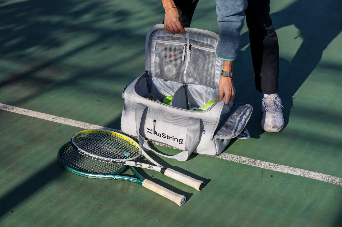 man holding ReString duffle open with two tennis rackets in hot sun next to him