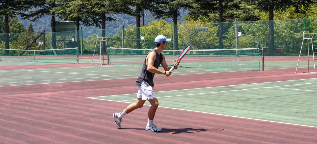 man playing tennis on hard court with tennis elbow
