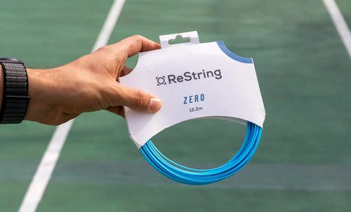 person holding ReString Zero string in its packaging