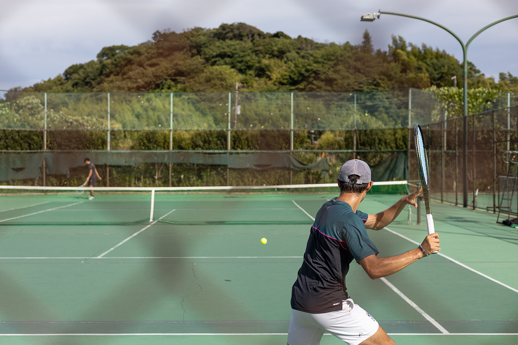 man about to hit tennis shot with spin