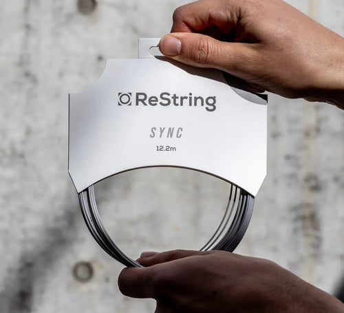 person holding ReString Sync string in its packaging